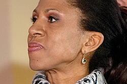 photograph of a light skinned Black woman looking off to the size with a pensive expression.