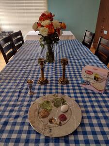 photograph of a dining room table with a seder plate and box of matzah