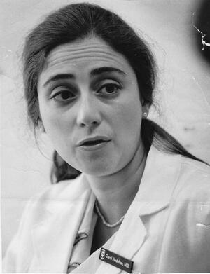 Portrait of Carol Nadelson speaking while wearing white lab coat and name tag