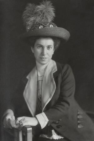 Josephine Levy-Rathenau, dressed in a hat and coat, leaning against an armrest