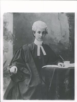 black and white photograph of a woman in black robes with a white wig