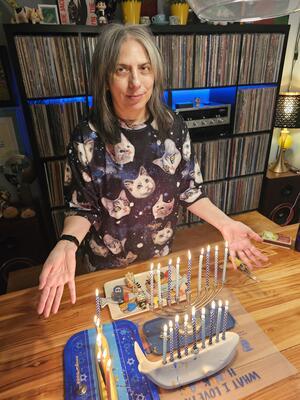 Tina Lerno with two lit menorahs