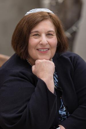 photo of a woman with her hand on a chin wearing a kippah