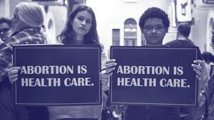 Two people holding signs