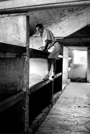 Man climbing onto barracks in concentration camp