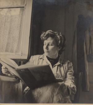 Black and white photo of artist Ruth Schloss with a large book