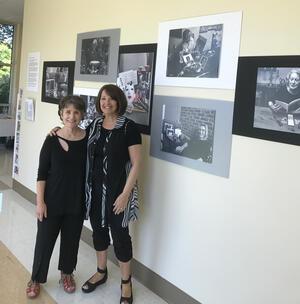 Barbara Rosenblit and Sheila Miller in front of a wall of photographs