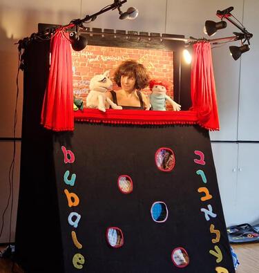 Woman with puppets on each hand staging a puppet show