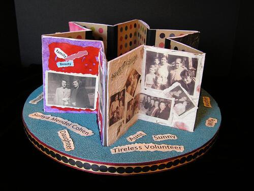 Star of David shaped paper sculpture with images and text on a circular base