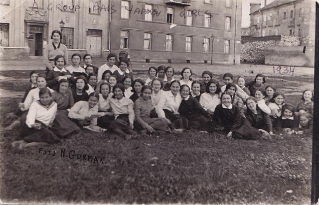 Students sit on ground posed for group photo outside Kraków Teachers' Seminary