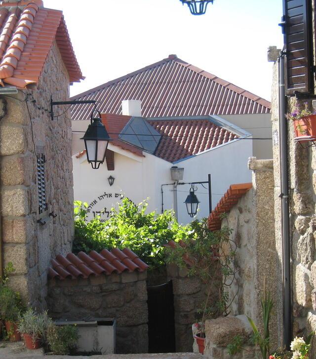 Exterior of the Belmonte with tile roof and street lamps outside on sunny day