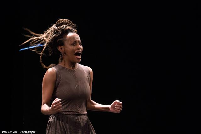 Dege Feder posing with her hands in fists, mouth open as if singing or shouting