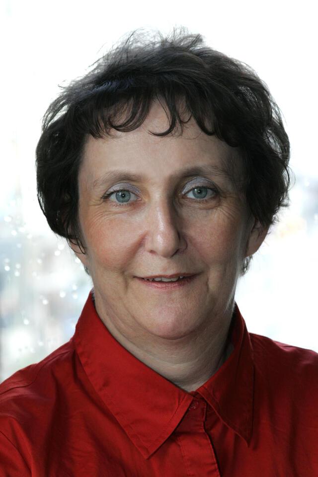Headshot of Rachel Galinne smiling and wearing a red top