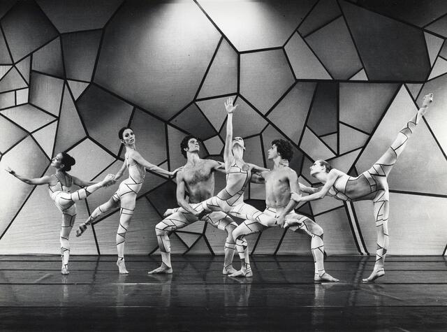 6 dancers from Bat-Dor Dance Company performing on stage in front of geometric backdrop in "Prism" choreographed by Mirali Sharon