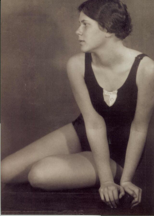 Judith Deutsch, wearing a swimsuit, kneeling and looking off-camera