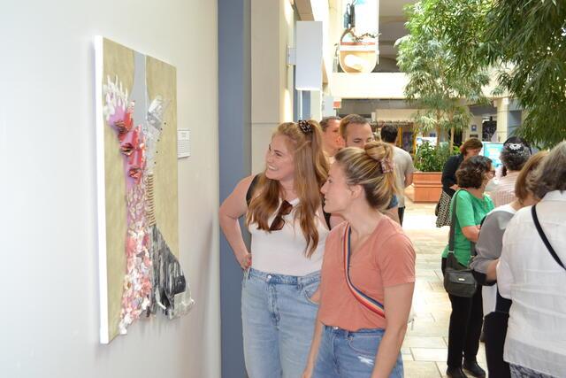 Jaime Stepansky and friend view her art piece, "Becoming," at Full Disclosure Exhibition