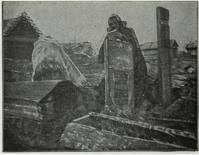 black and white photograph of a woman measuring a grave in Russia