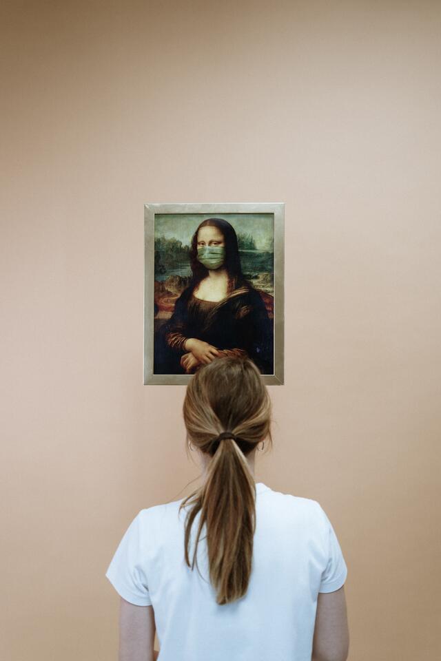 Woman Looking at Painting of Mona Lisa with Face Mask.